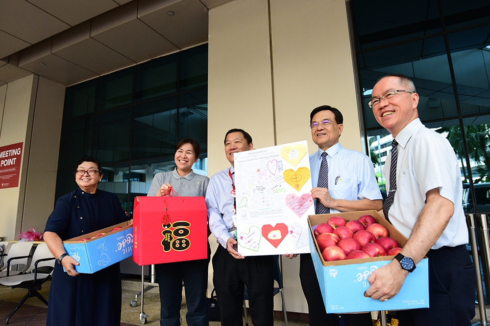 执行长刘瑞士（右二）与志工代表把福袋、水果礼篮和大型祝福卡送给陈笃生医院医务理事会主席秦经智。(摄 / 王绥喜)